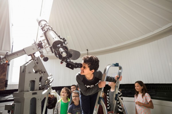 Een jongetje bekijkt de zon door de grote zonnetelescoop op Sonnenborgh