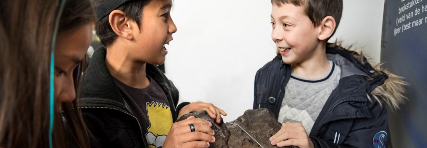Twee jongens raken de megameteoriet van Sonnenborgh van 4,5 miljoen jaar oud aan