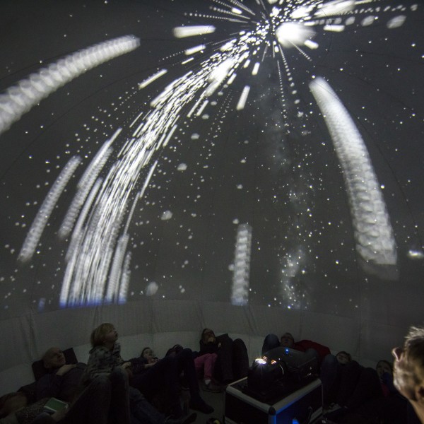 Bezoekers kijken naar sterren in het planetarium