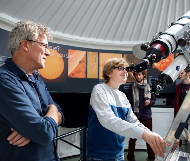 Jongen kijkt door de zonnetelescoop van Sonnenborgh