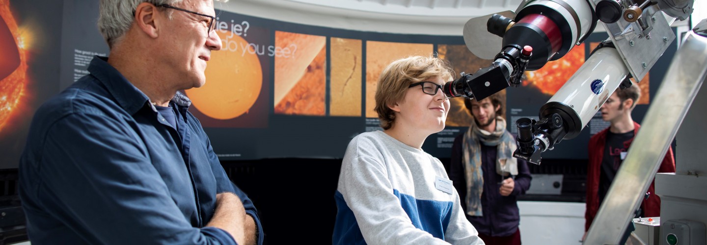 Jongen kijkt door de zonnetelescoop van Sonnenborgh