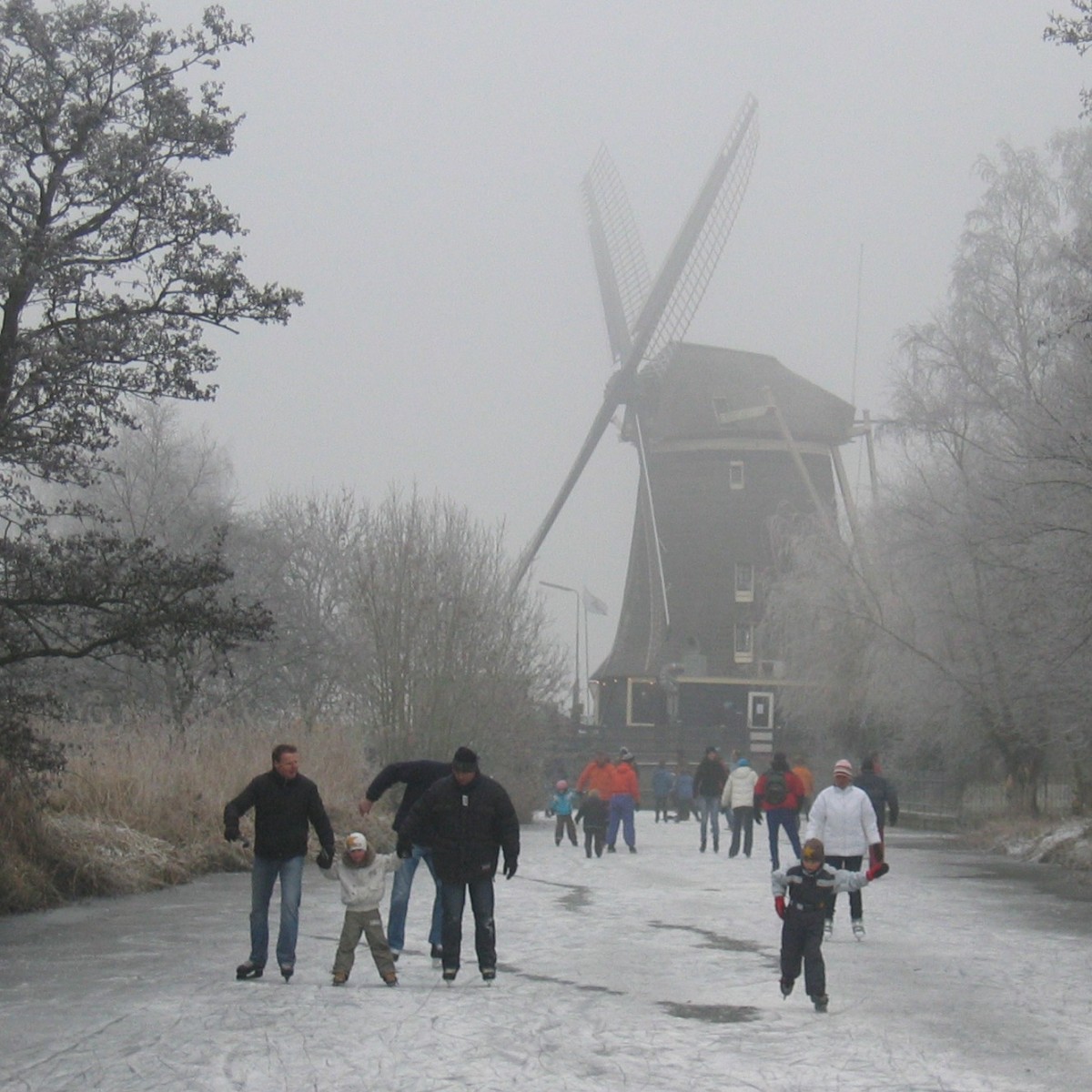 Schaatsers bij een molen